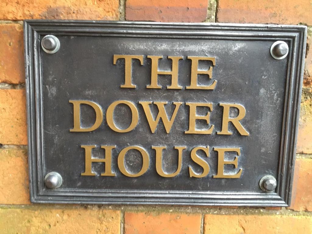 um sinal que diz a casa doter em uma parede de tijolos em The Dower House Apartments em Lincoln