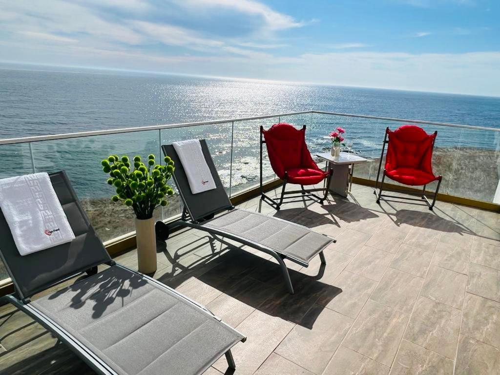 a balcony with chairs and a table and the ocean at Alessio Hotel Residence in Costinesti