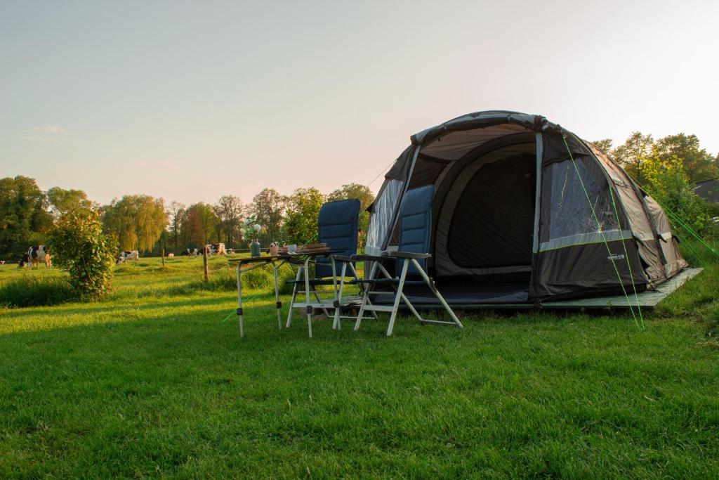 una tienda y una mesa con sillas en un campo en camping?glamping morskersweitje en Winterswijk