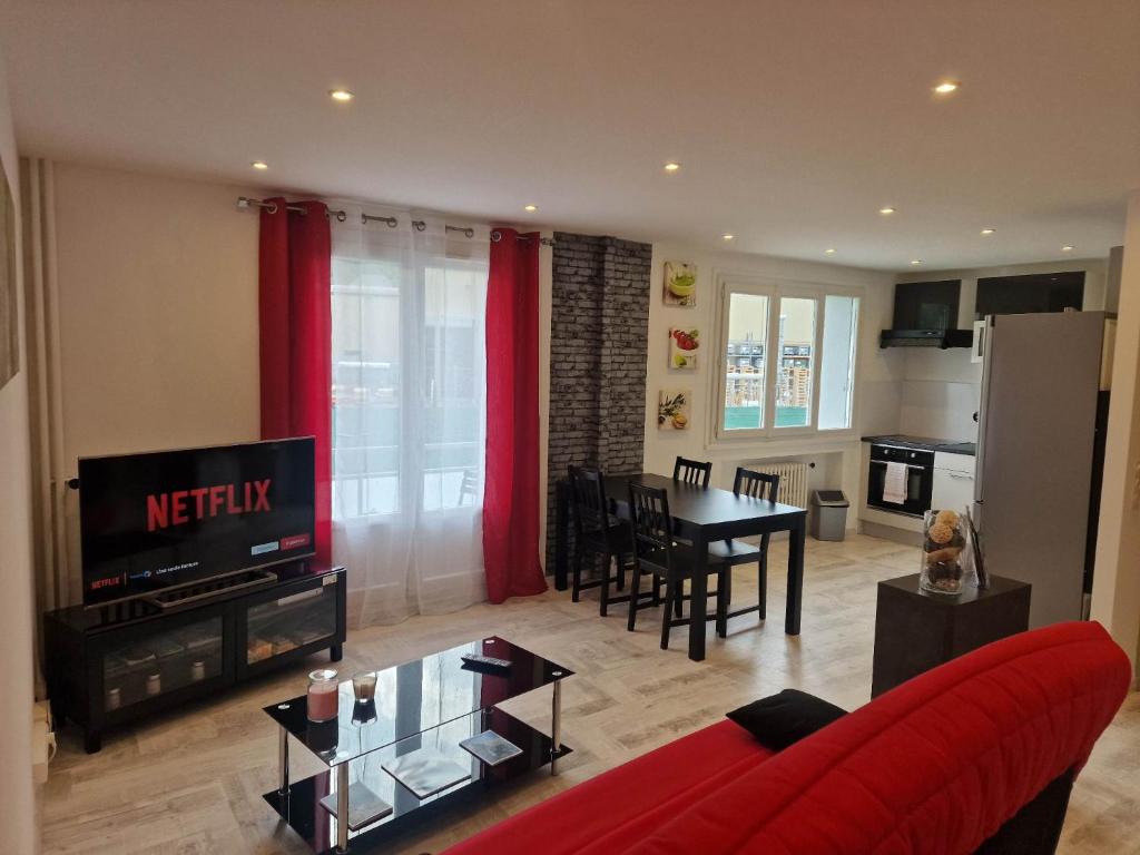 a living room with a red couch and a table at Superbe appartement 2 pièces - Aix-les-Bains Riviera des Alpes - Parking gratuit in Aix-les-Bains