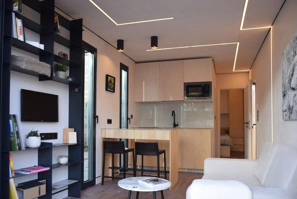 a living room with a white couch and a kitchen at tiny house in Rotterdam