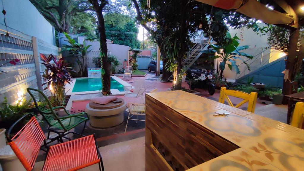 a patio with a table and chairs and a pool at Taguato B & B in Asunción