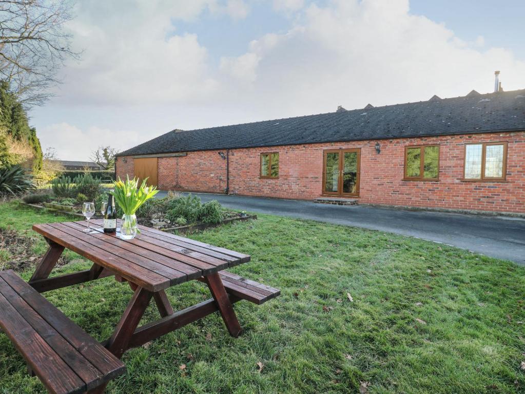 a picnic table in front of a brick building at Adelaide Cottage in Ashbourne