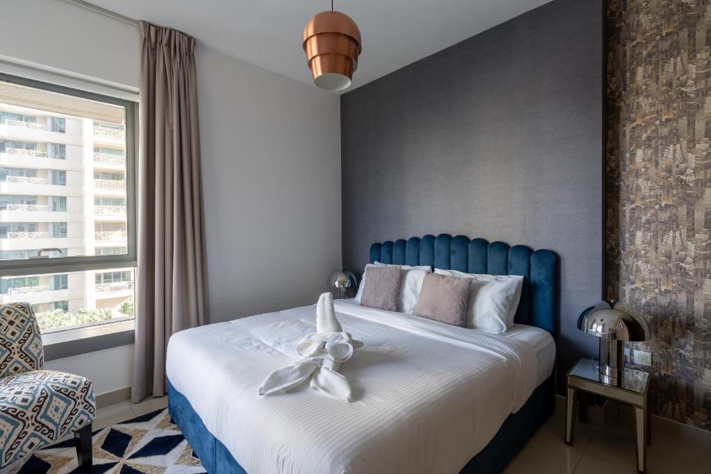 um quarto com uma cama azul com um arco branco em BellaVista 2 BR 29 Boulevard Downtown Burj Khalifa em Dubai