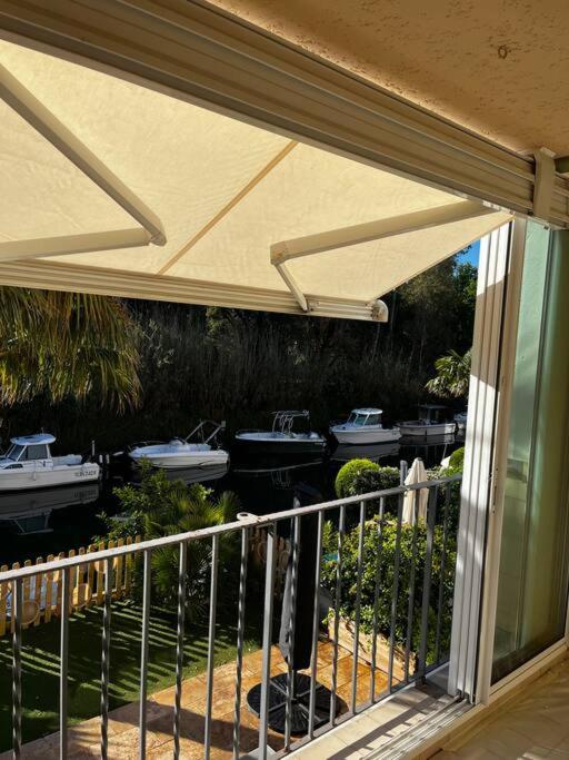 un patio avec un auvent et des bateaux dans l'eau dans l'établissement Bel Appartement au coeur de la Marina Port Cogolin, à Cogolin