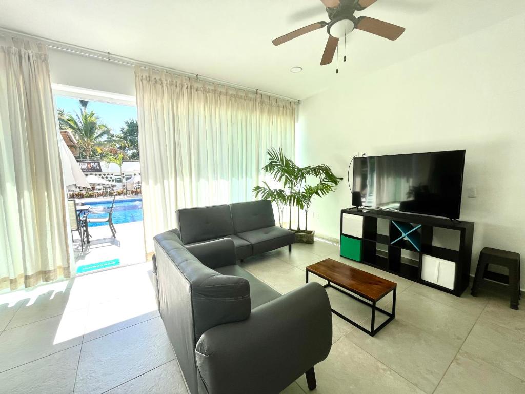 a living room with a couch and a flat screen tv at Residencial Gran Palma in Acapulco