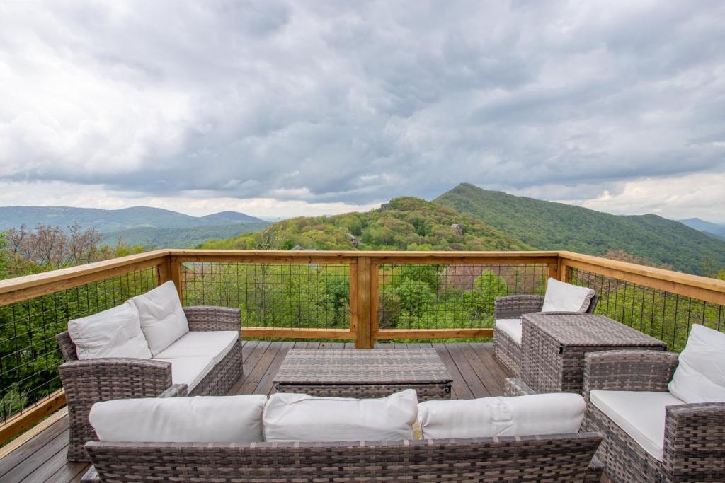 eine Terrasse mit Stühlen und Sofas auf einem Balkon mit Bergblick in der Unterkunft Top of the World in Seven Devils