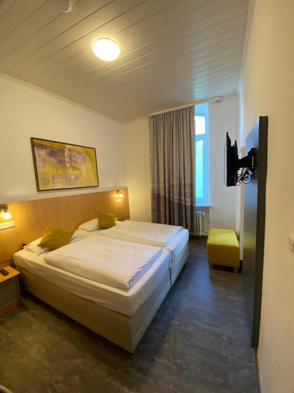 a hotel room with a bed and a tv at Hotel Krone in Bingen am Rhein