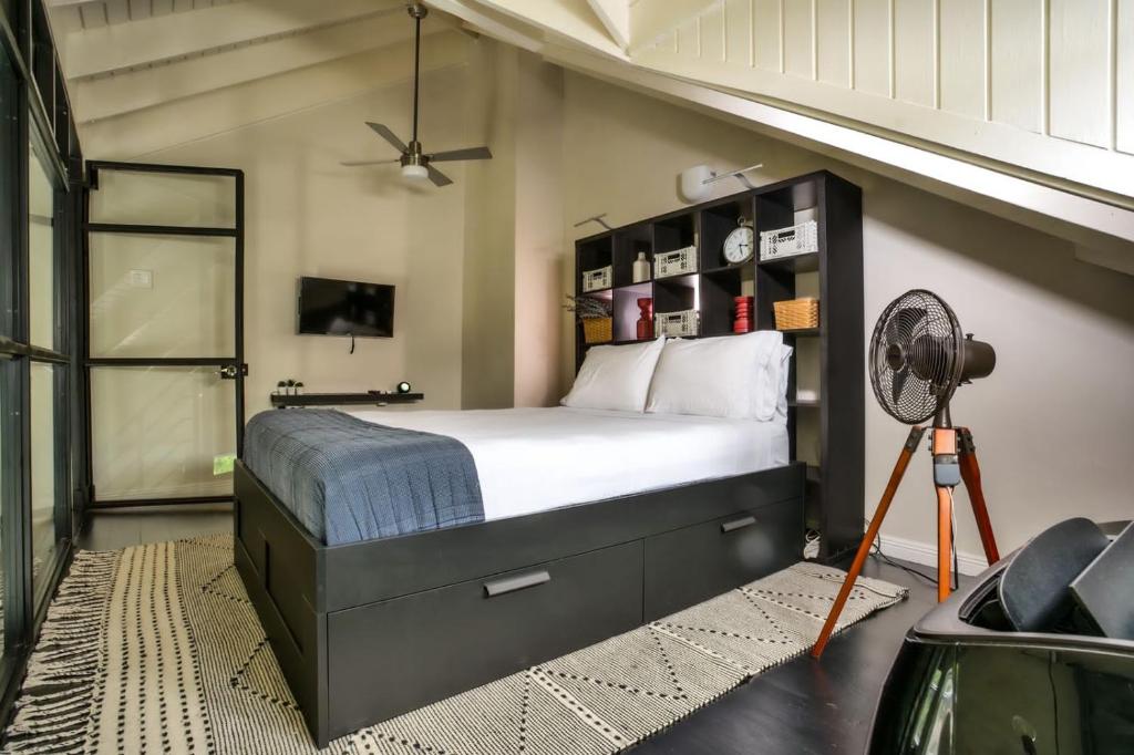 ein Schlafzimmer mit einem großen Bett und einem Ventilator in der Unterkunft Choose To Be Happy at EI8HT! - Super Studios and Penthouse Apartment in Kingston