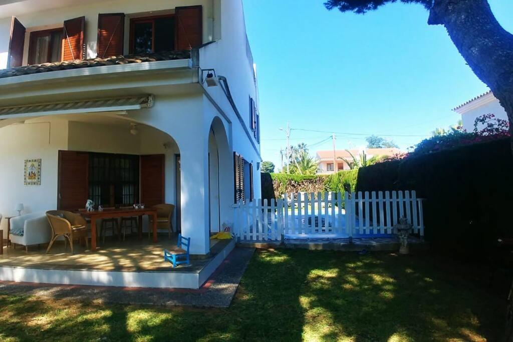 ein weißes Haus mit einem Tisch im Hof in der Unterkunft Villapolonia, casa 8 pax. piscina y aire ac. in Benicàssim