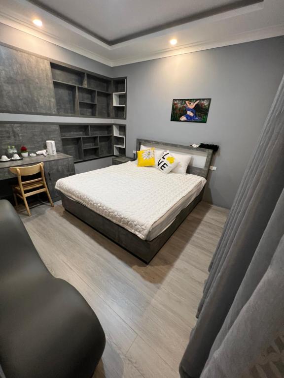 Schlafzimmer mit einem Bett, einem Schreibtisch und einem Stuhl in der Unterkunft BALI HOTEL in Ấp An Bình