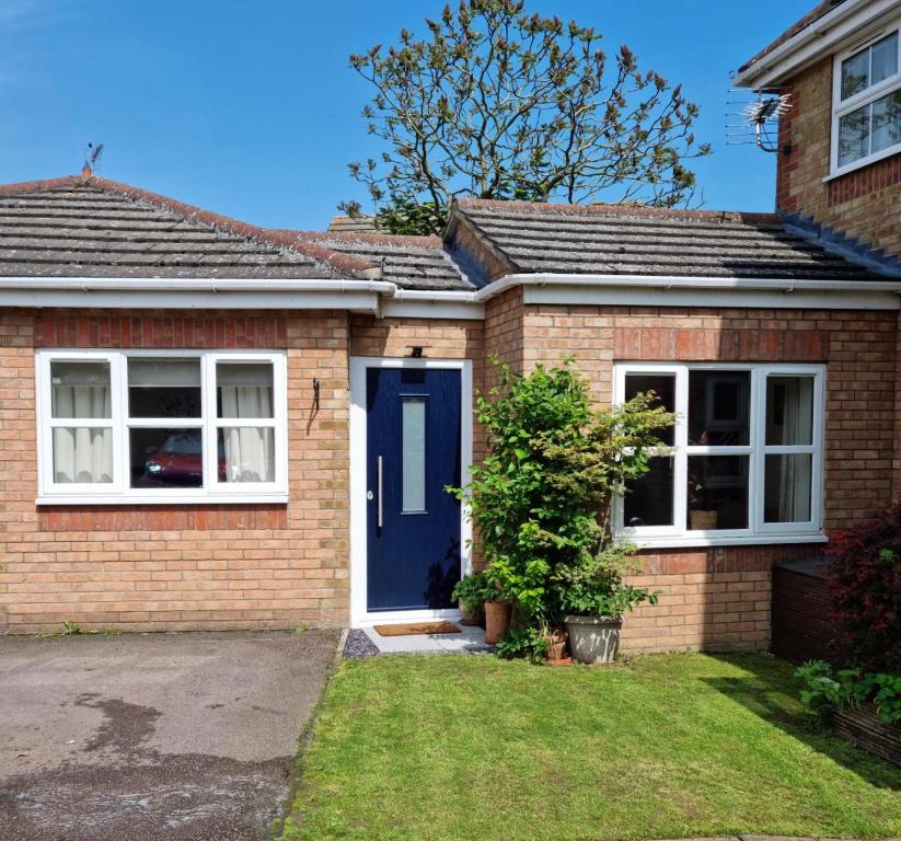 a red brick house with a blue door at Beautiful studio in Ely in Ely