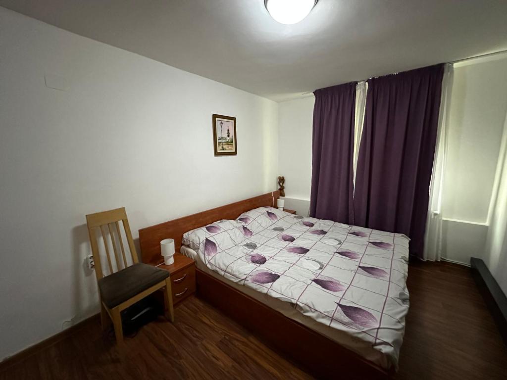 a small bedroom with a bed and a chair at Pool Garden-Oaza in Skopje