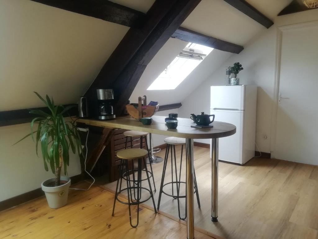 uma cozinha com uma mesa, bancos e um frigorífico em Gare-Arquebuse em Dijon