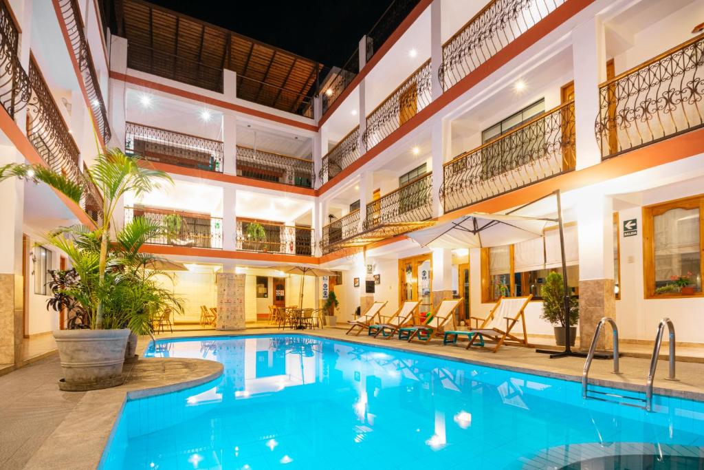 een groot zwembad in een groot gebouw met een zwembad bij Hotel Las Flores in Ica