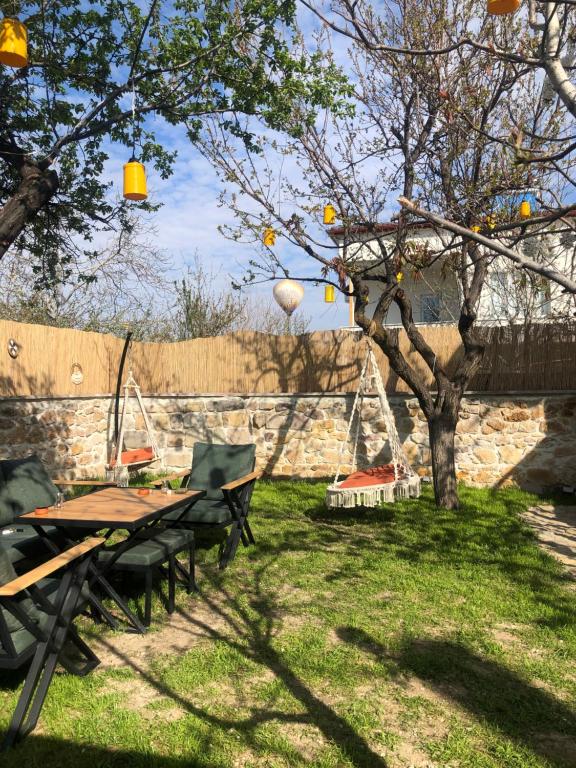 a picnic table and chairs under a tree in a yard at Casa Di Cappadocia in Uchisar