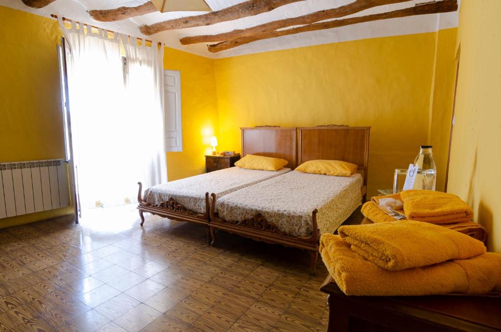 1 dormitorio con 2 camas en una habitación amarilla en Turismo Rural La Ojinegra en Alloza