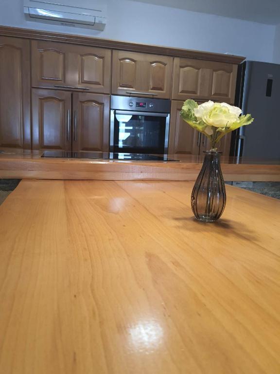 un vaso con fiori gialli seduto su un tavolo di legno di Apartment Dort a Capodistria