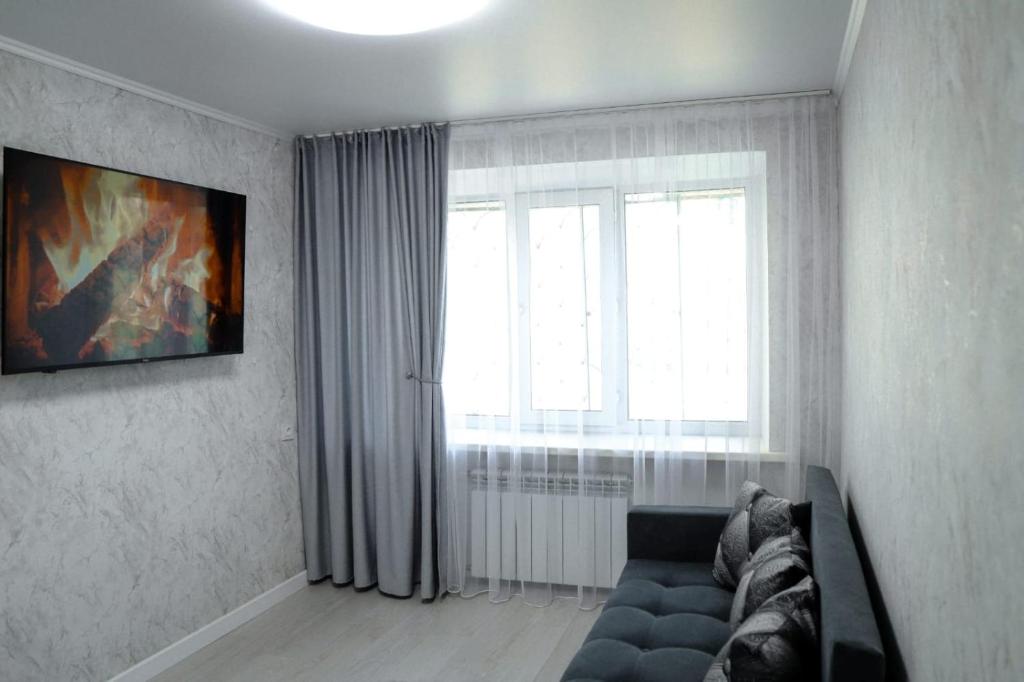 sala de estar con sofá y ventana en Tatyana-Hotel en Kostanái
