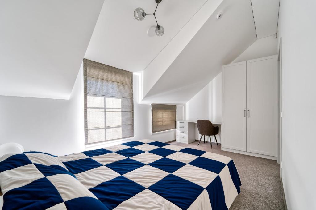 um quarto com uma cama de xadrez azul e branco em Karklės Oazė em Karklė