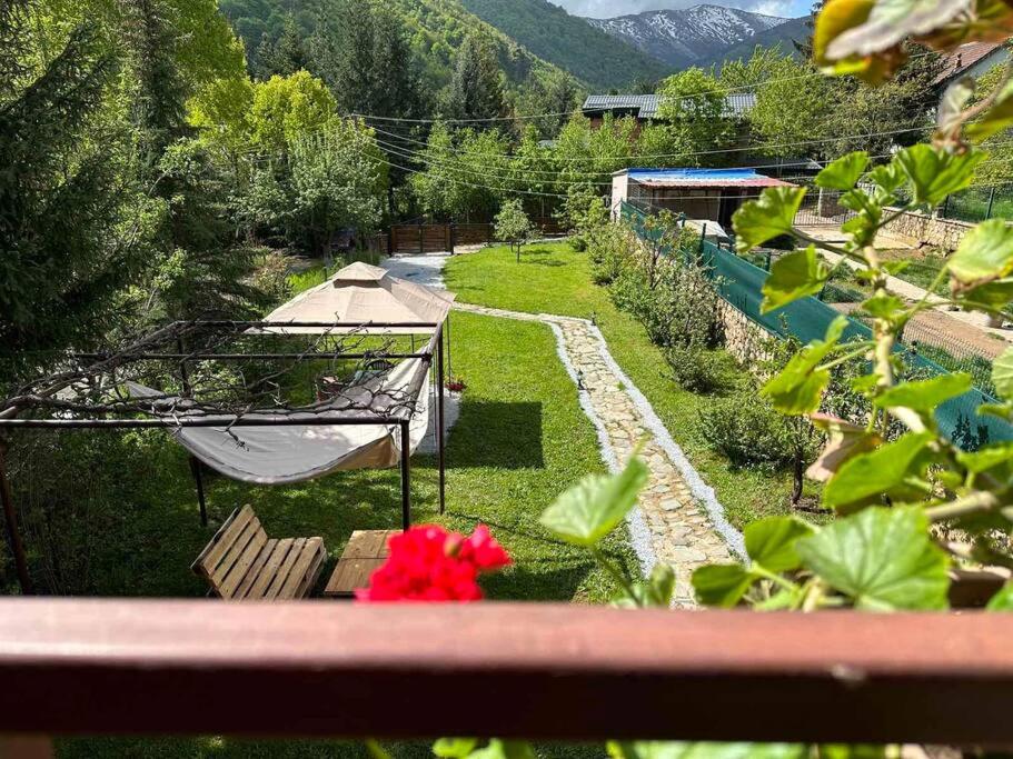 a view of a garden with a tent and flowers at Cosy Mountain Villa in Nizepole in Bitola