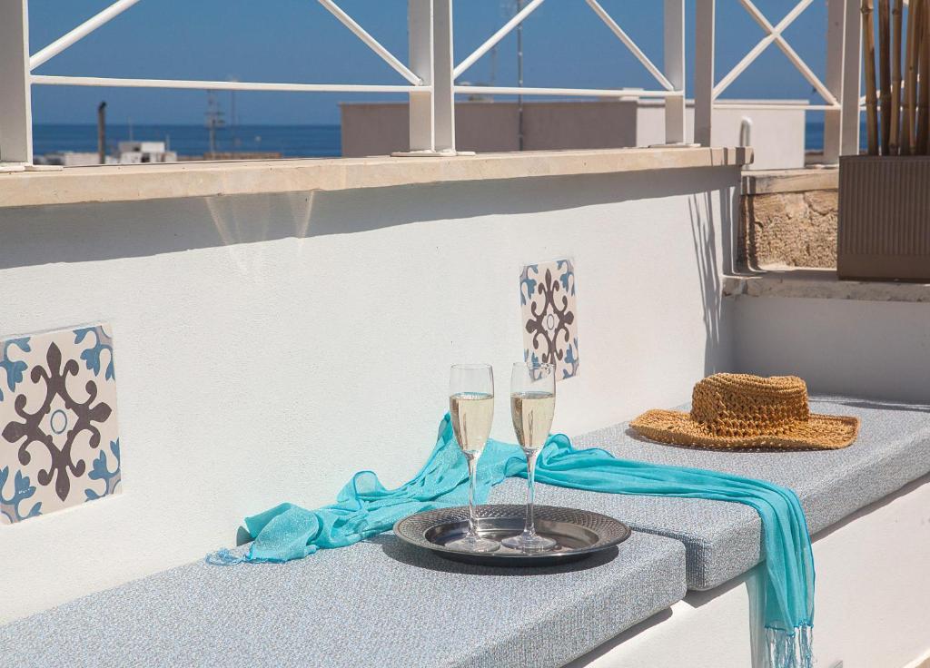 uma mesa com duas taças de champanhe numa varanda em NEREA - Apulian Suite and Rooms em Monopoli