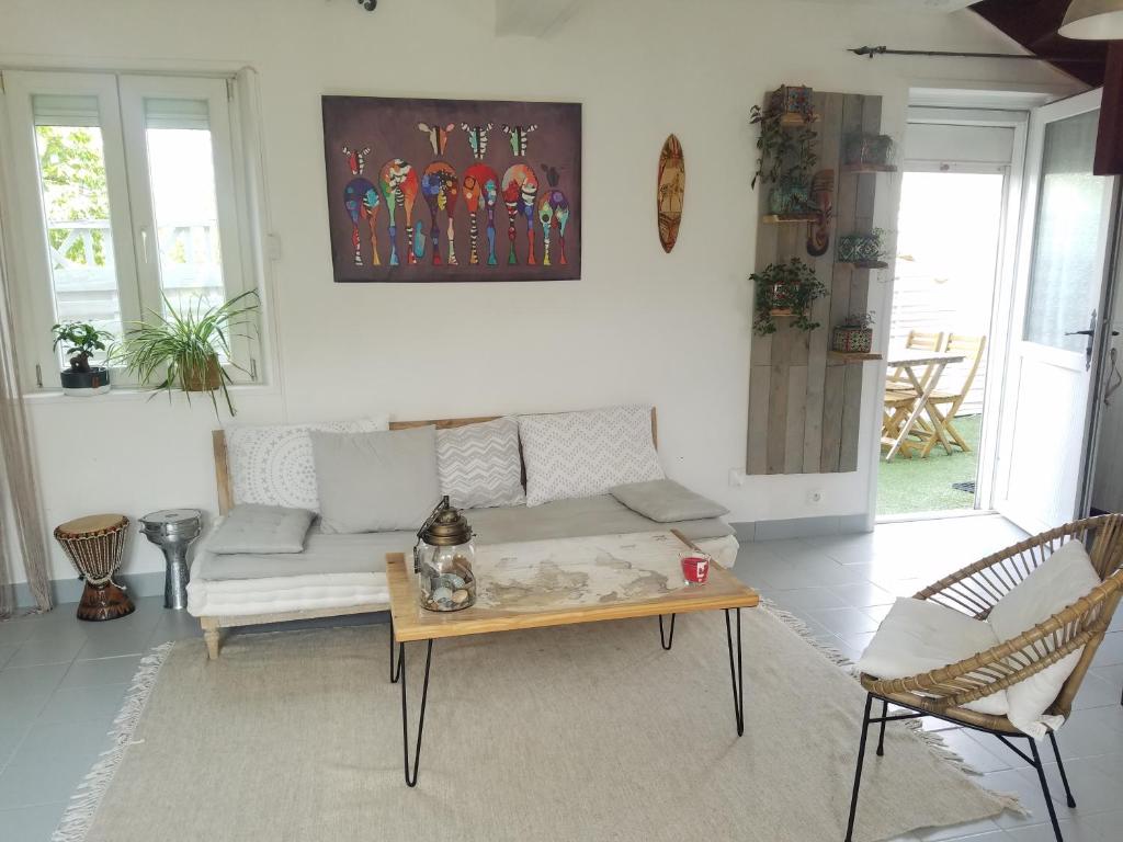 un salon avec un canapé et une table basse dans l'établissement Maison de village, à Le Breuil-en-Auge