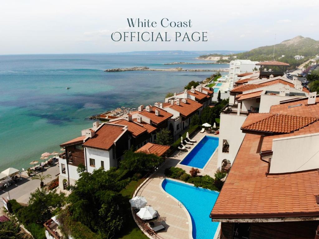 a view of a resort with a pool and the ocean at White Coast Beach Apartments in Kavarna