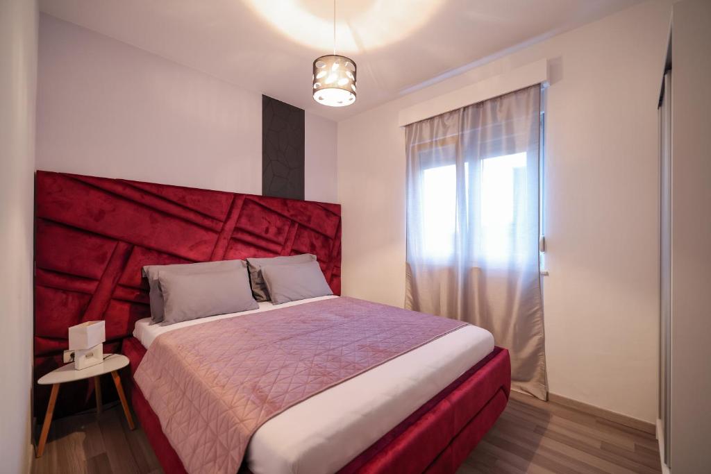 a bedroom with a large bed with a red headboard at Boutique Apartments Ad Astra in Bibinje