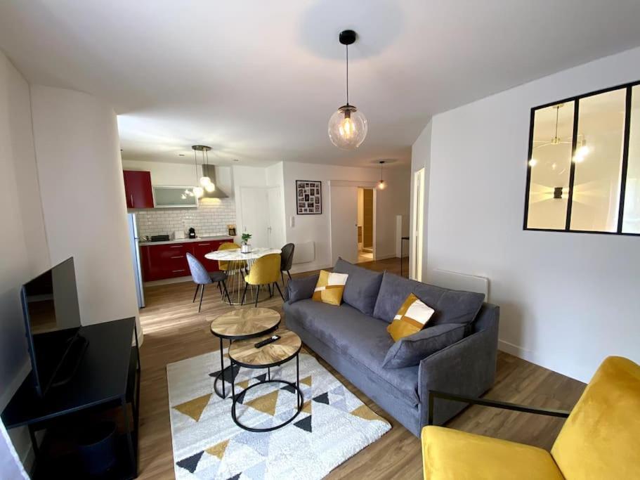 un soggiorno con un divano blu e un tavolo di Proche festival - centre - lave-linge - wifi fibre ad Avignone