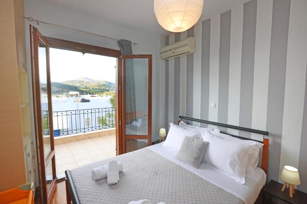 a bedroom with a bed with a view of a balcony at Mesaria House Syros in Ermoupoli
