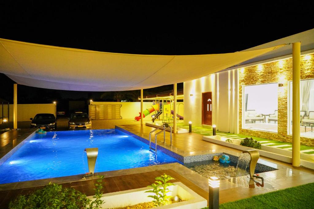a swimming pool in the middle of a house at night at Bahja Challet in As Suwayq