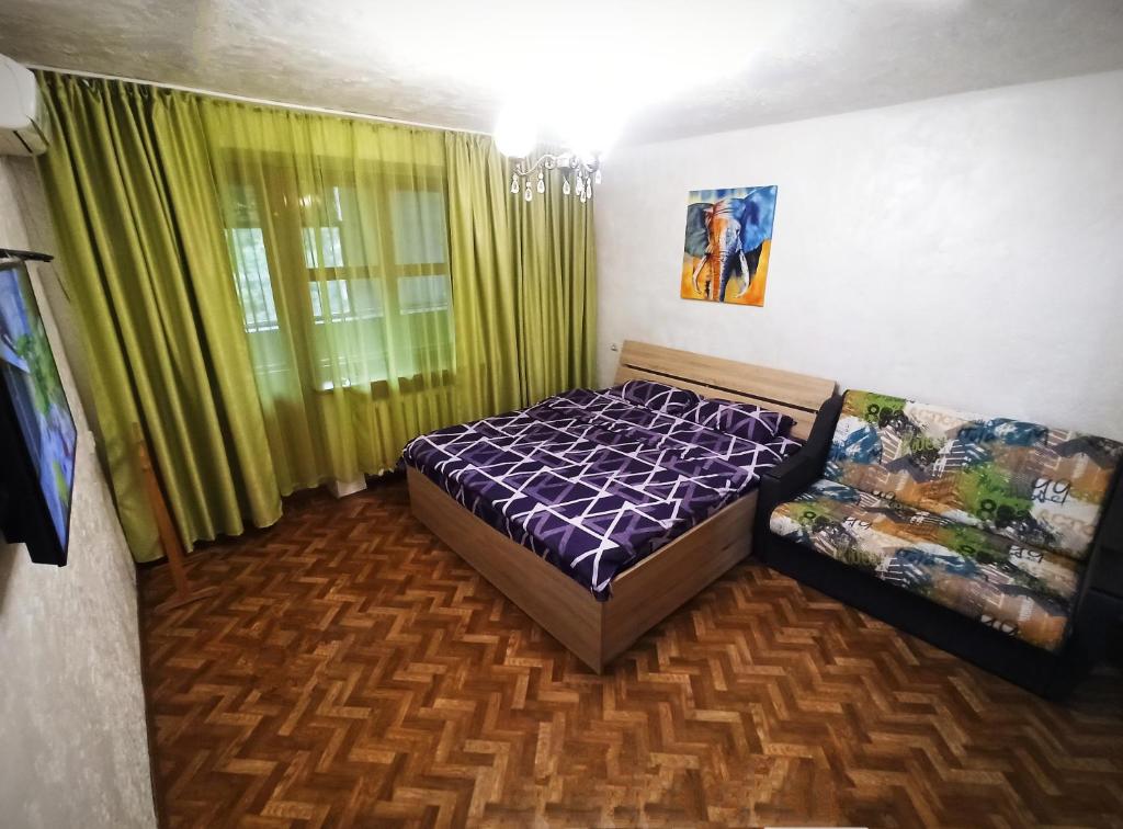 um quarto com uma cama e uma janela com cortinas verdes em 3 кімнатна квартира на вул. Калинова. em Dnipro