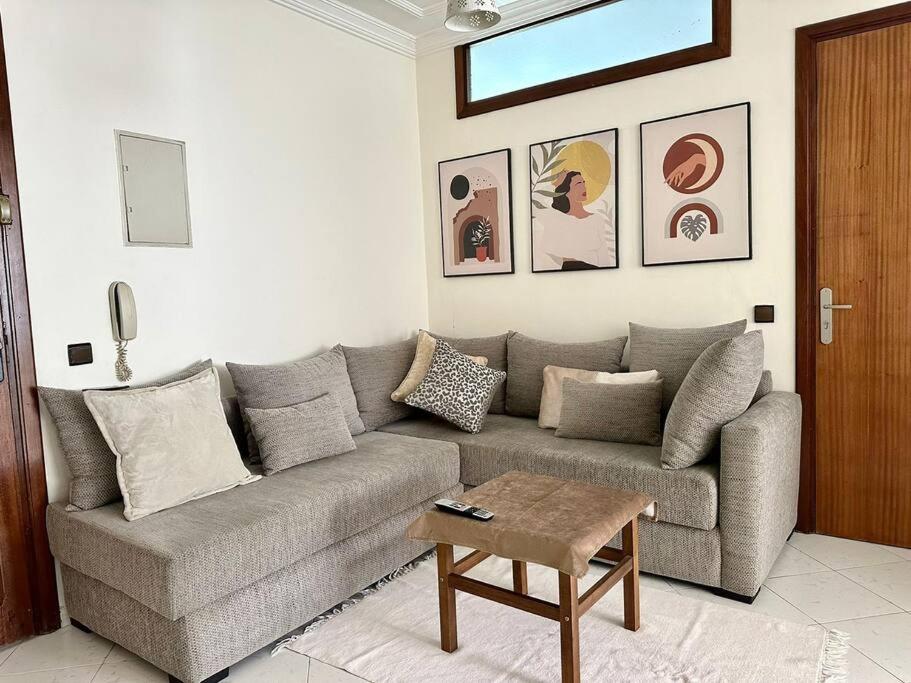 a living room with a couch and a table at Rabat, Appartement Neuf en face d'Arribat Center. in Rabat