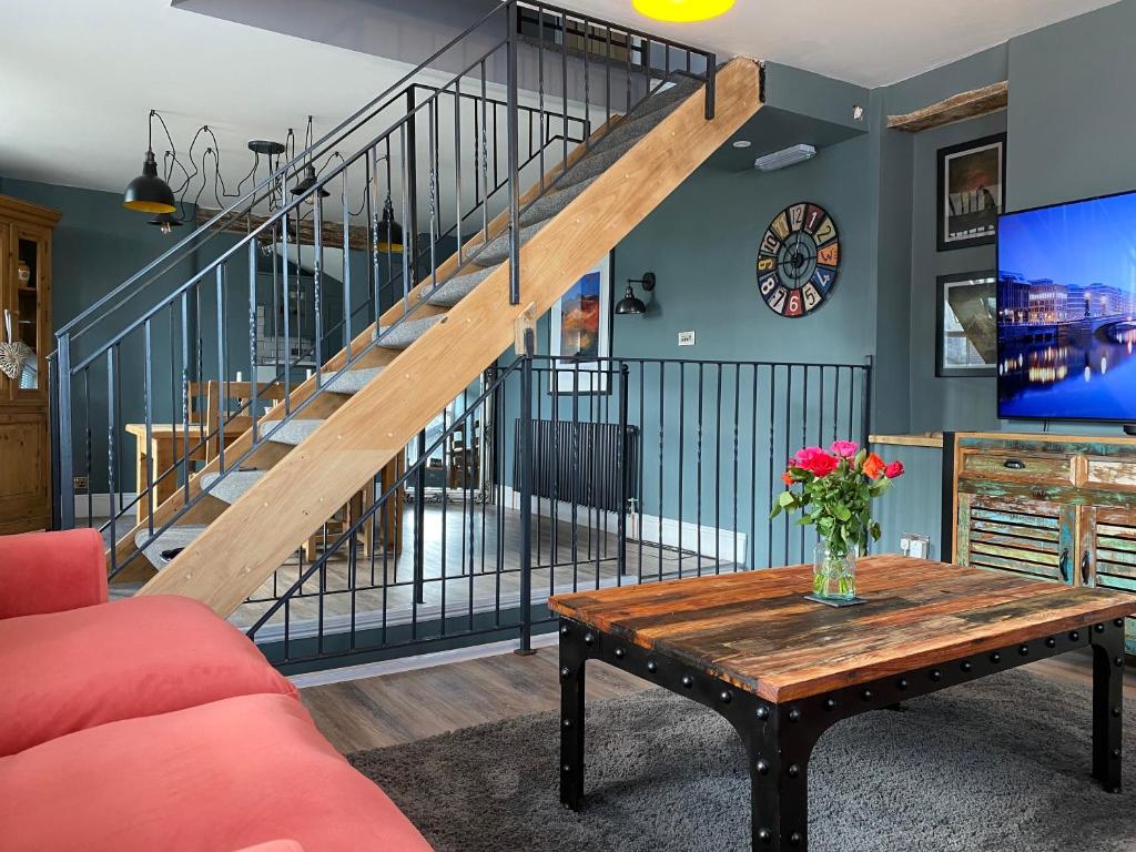 een woonkamer met een tafel en een trap bij High Street Apartment in Windermere