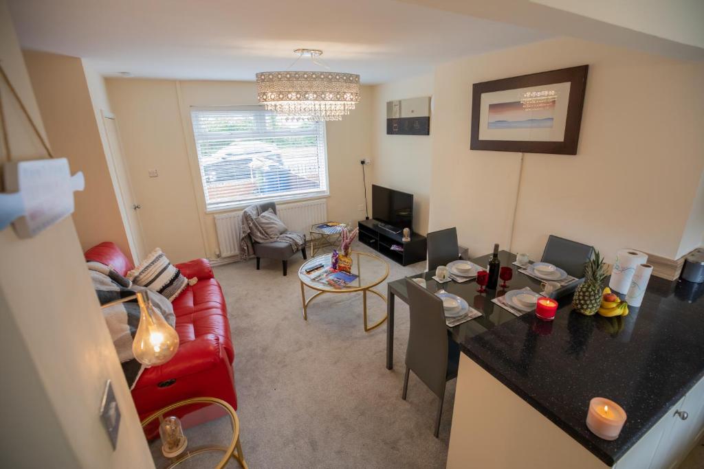 a living room with a red couch and a table at OG Tranquil Homes - Contractor & Family Friendly, FREE WiFi & Parking, Laptop friendly, Garden in Sunderland