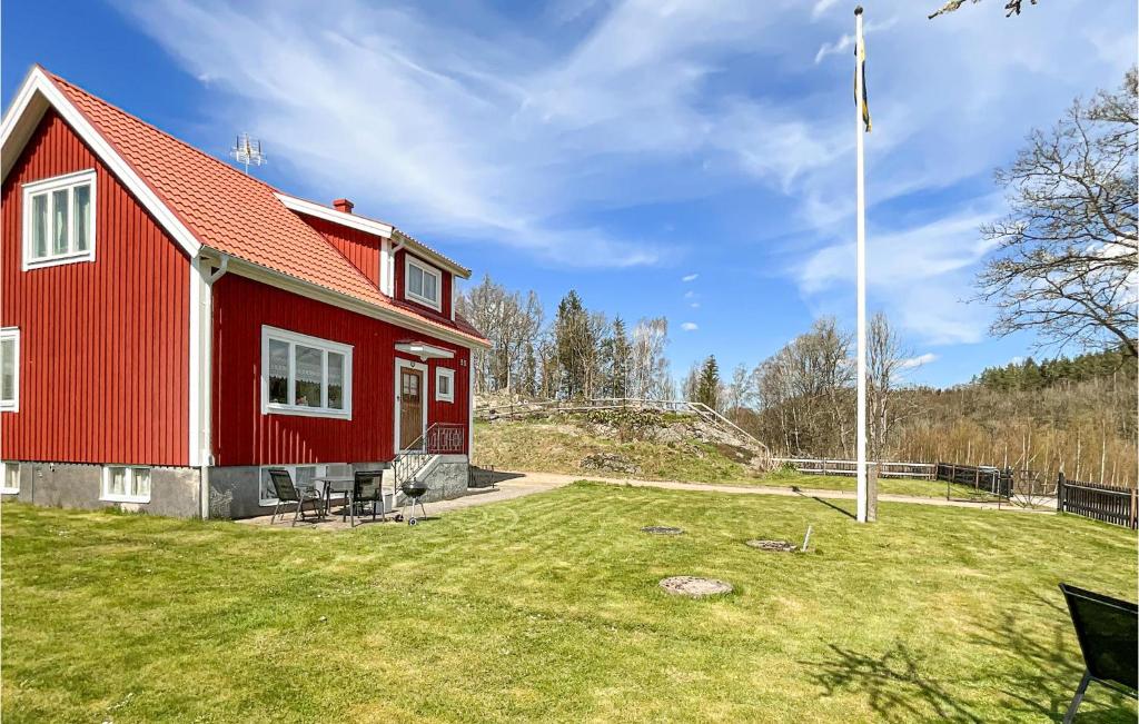 a red house with a flag in the yard at Awesome Home In Tving With Wifi And 3 Bedrooms in Tving