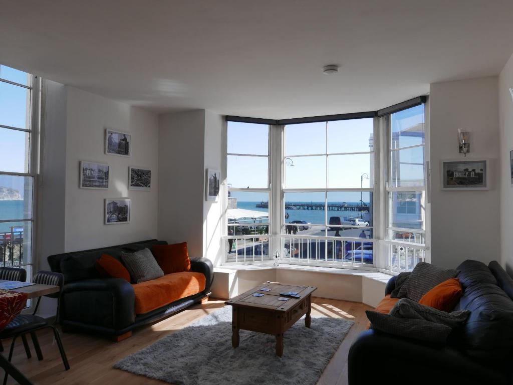 a living room with two couches and a large window at SeaViewApartment in Swanage
