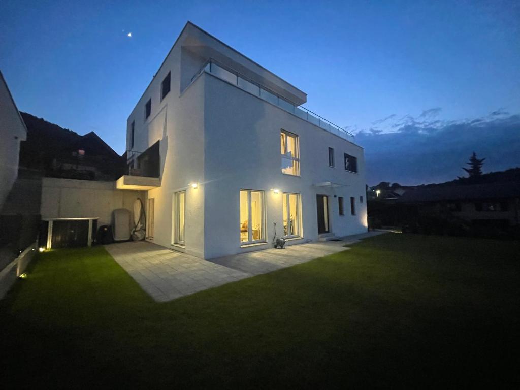 a white house with a large yard at night at V.I.P Appartement in Böttstein