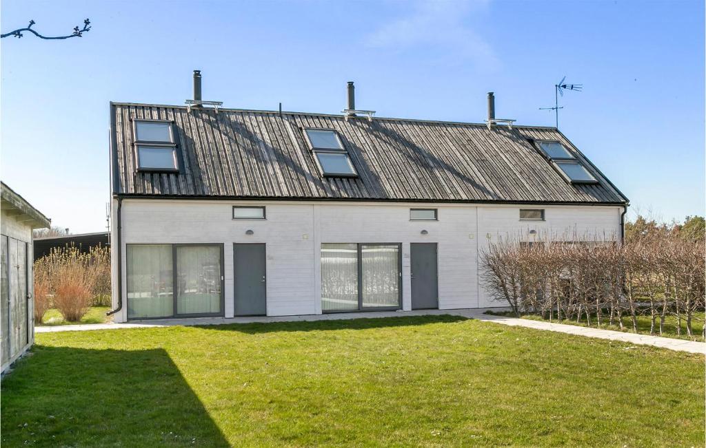 una casa blanca con techo de metal en 3 Bedroom Nice Home In Burgsvik, en Burgsvik