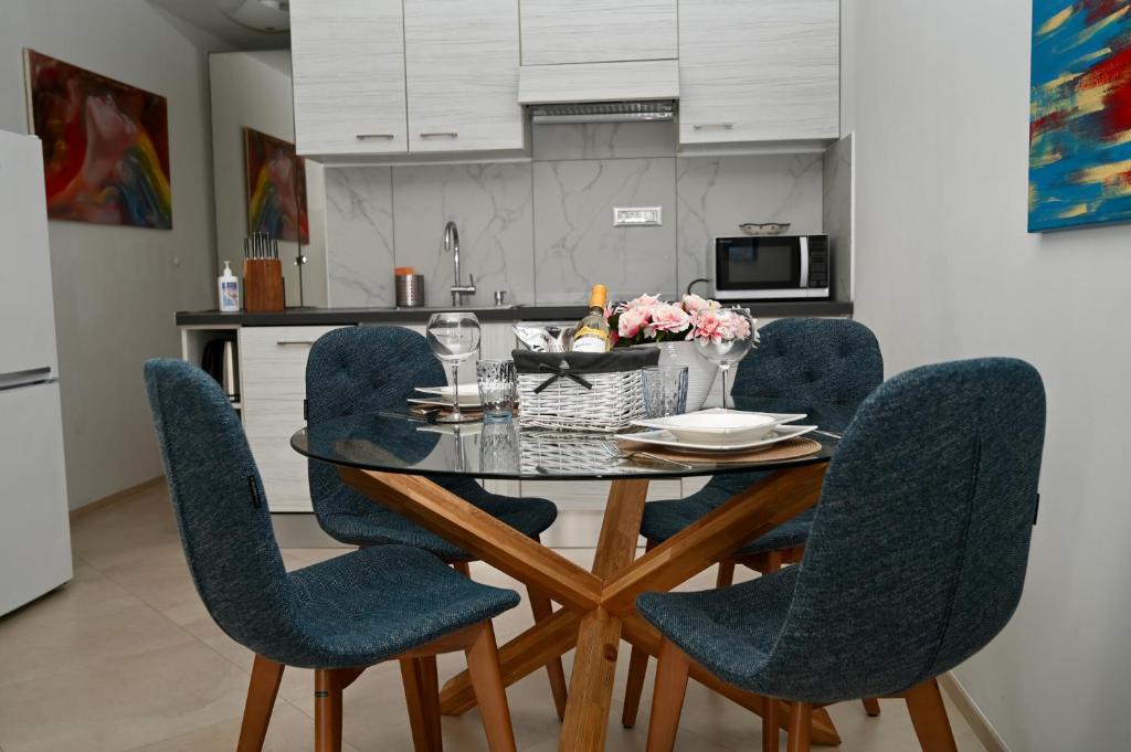 stół jadalny z niebieskimi krzesłami w kuchni w obiekcie Sea Star Apartment w Koprze