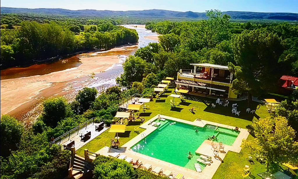 una vista aérea de una piscina junto a un río en Balcón del Río, Hotel de Campo y Cabañas en Mina Clavero