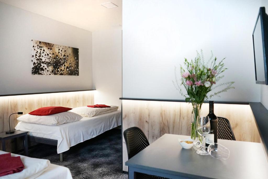 ブルノにあるPenzion Smileのベッド2台、テーブル(花付)が備わる客室です。