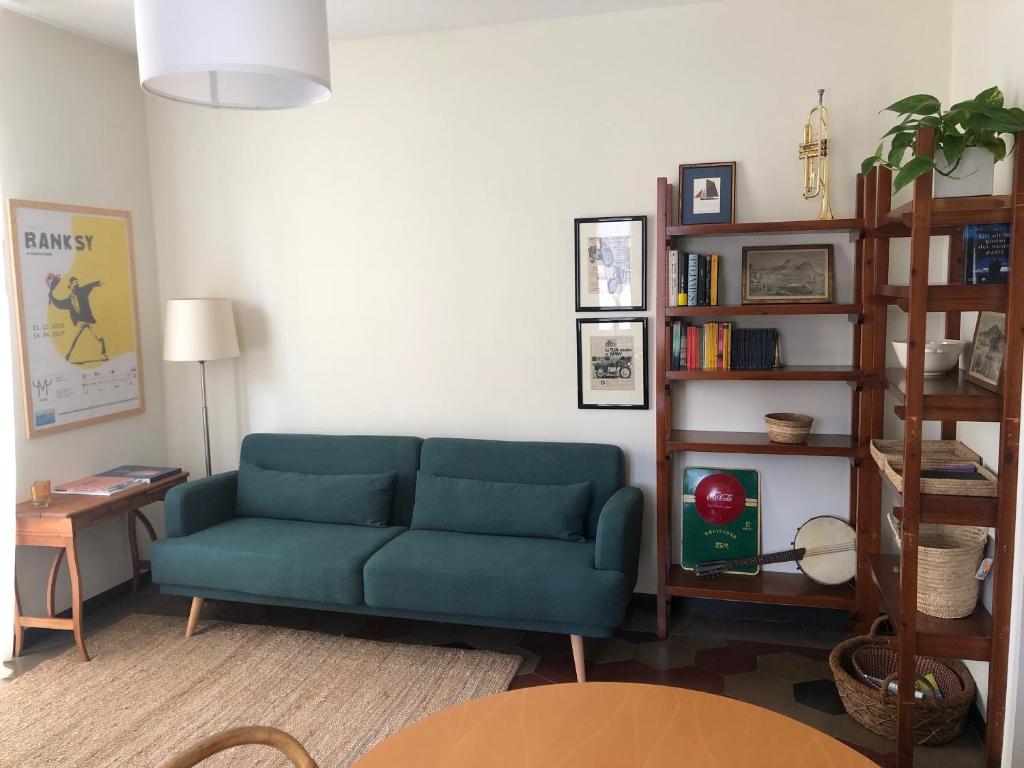 een woonkamer met een blauwe bank en een boekenplank bij Casa Vacanze Labiena 129 in Laveno