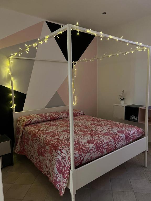 - une chambre avec un lit à baldaquin éclairé dans l'établissement B&B Il Corallo, à Terracine