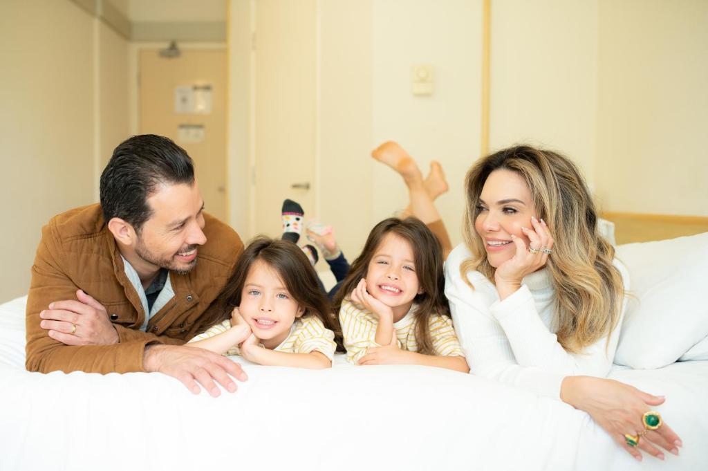 a family laying on a bed at ibis Taubate in Taubaté