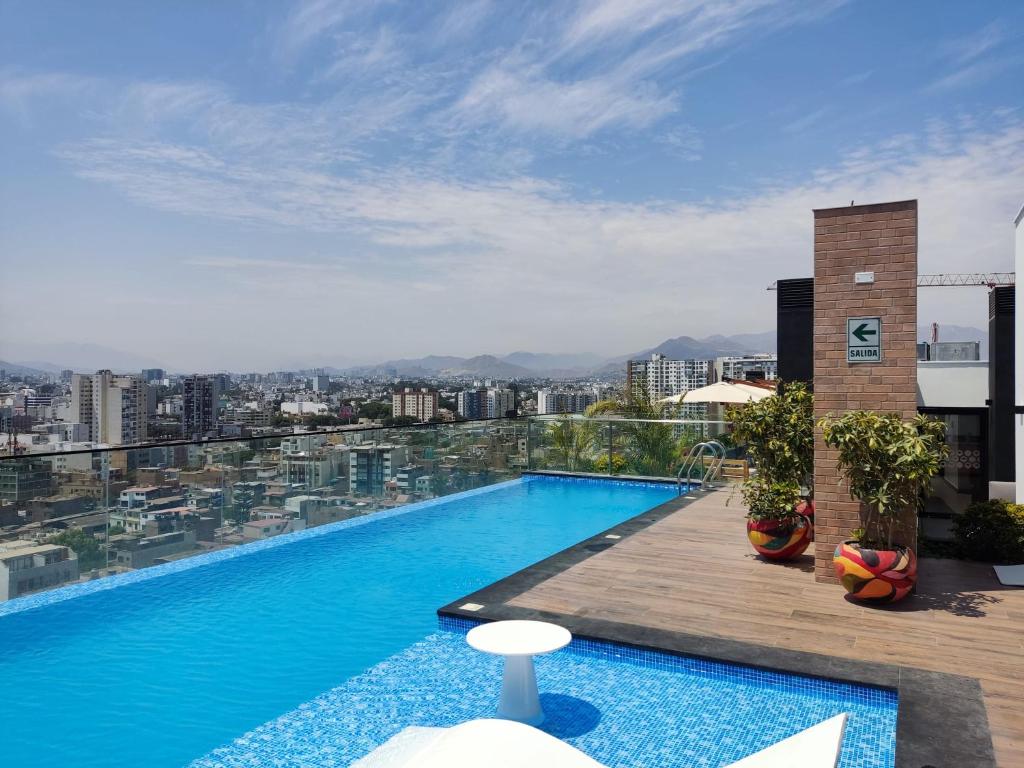 a swimming pool on top of a building with a city at El Sol by Wynwood House in Lima