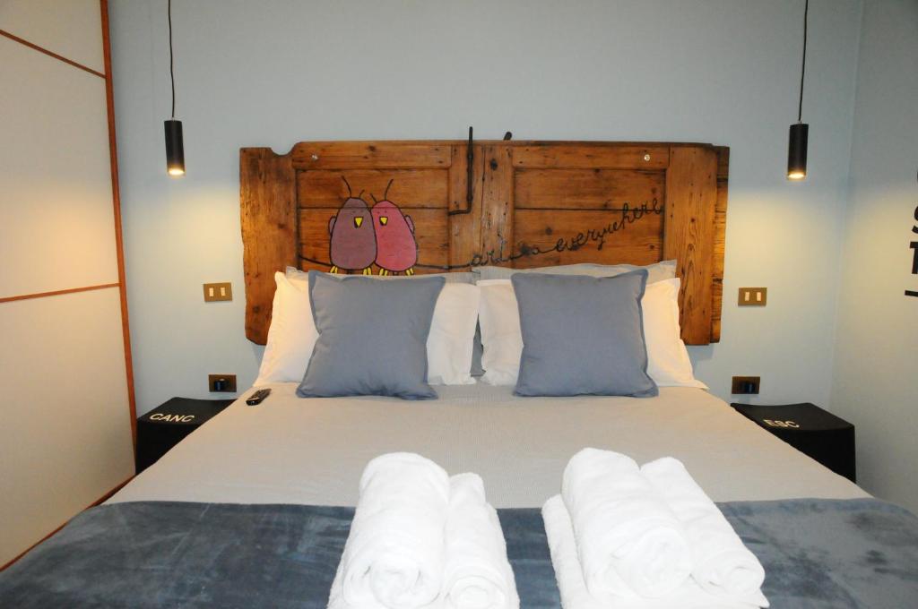 a bedroom with a large bed with a wooden headboard at ADRIA ART APARTMENTS 1 in Adria