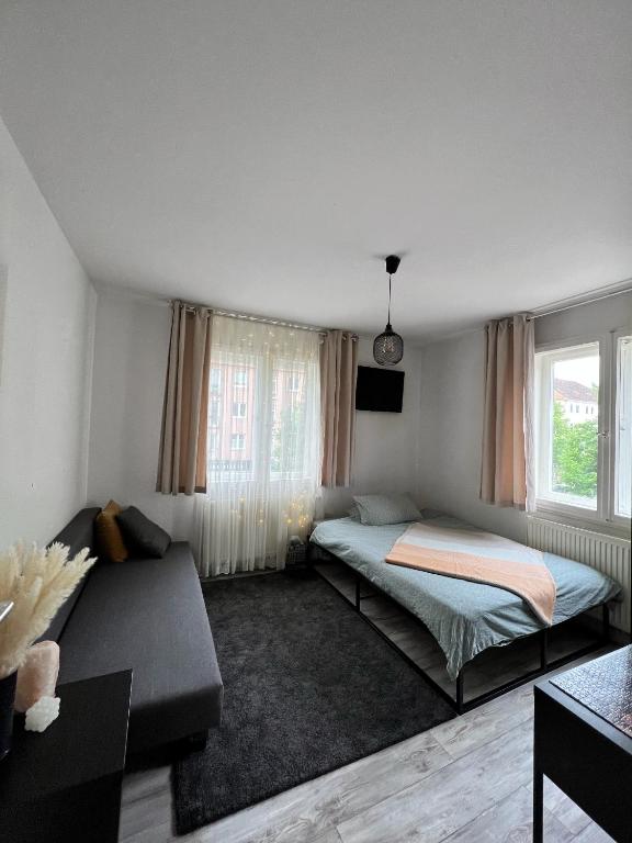ハノーファーにある1 Room Apartment in City of Hannoverのベッドルーム1室(ベッド2台、ソファ付)