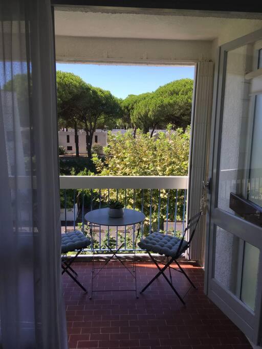 - un balcon avec 2 chaises et une table sur une terrasse couverte dans l'établissement T2 très agréable et proche de la mer, à La Grande Motte